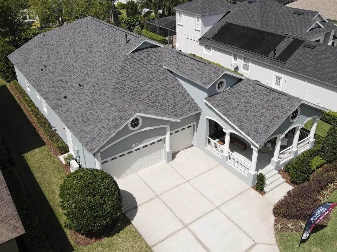 Aerial view of a gray home with a high-performance asphalt shingle roof, attached garage, and covered front porch in Ashippun, Wisconsin.