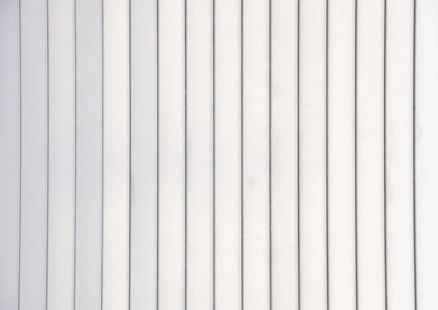 White vertical paneled wall or ceiling with evenly spaced grooves