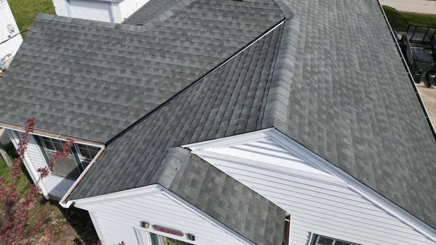 Aerial close-up of a home with gray asphalt shingle roofing and white siding in Menomonee Falls, Wisconsin.