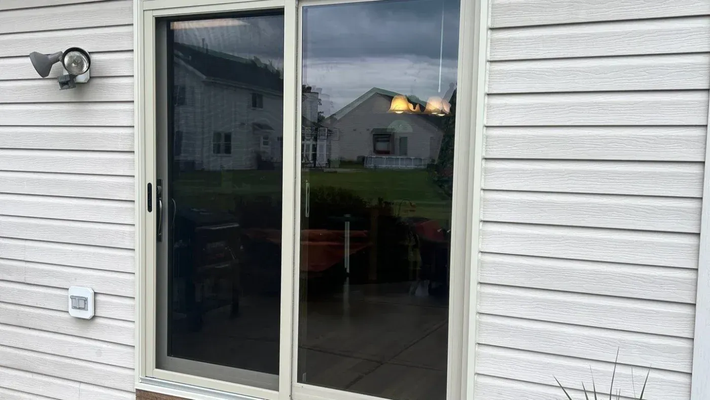 Sliding glass patio door installed on a home with white siding in Milwaukee, Wisconsin.