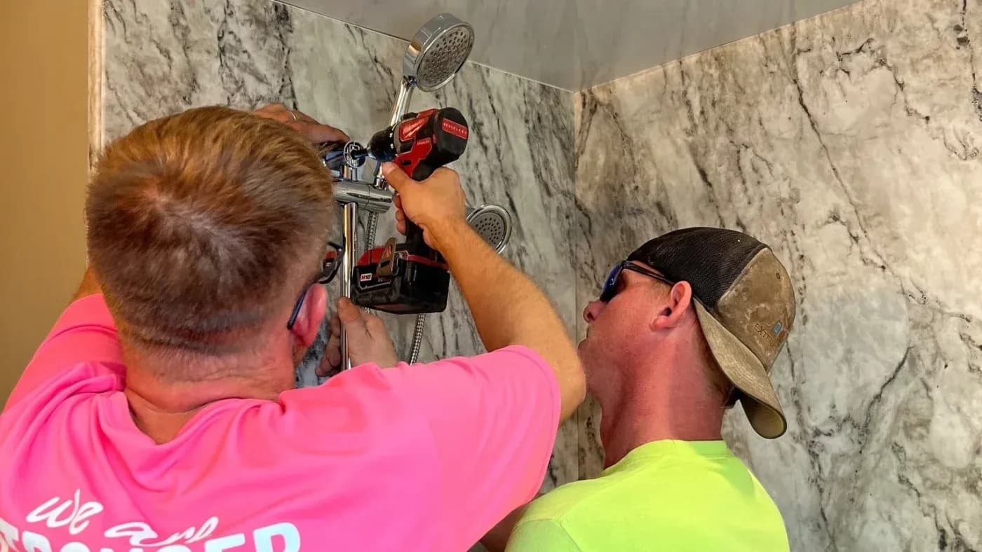 ALT: Two installers securing a handheld shower fixture during a bathroom shower installation in Milwaukee, Wisconsin.