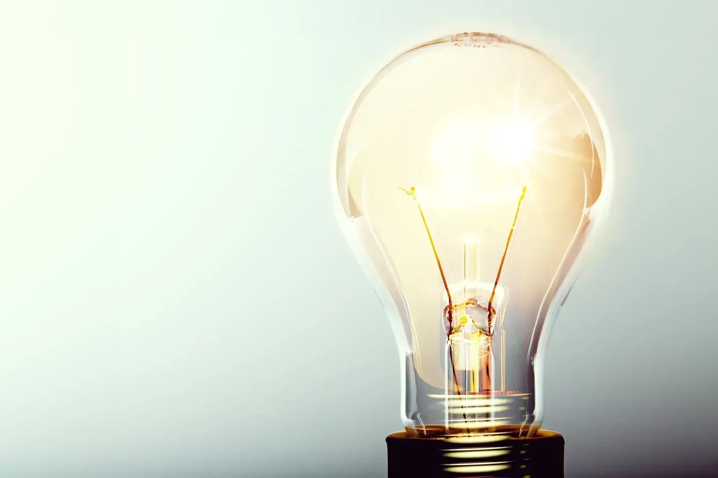 Glowing light bulb on a neutral background symbolizing bright ideas, innovation, and professional home remodeling solutions.