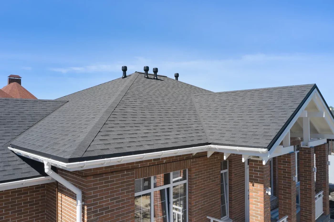 brown home with a dark asphalt shingle roof