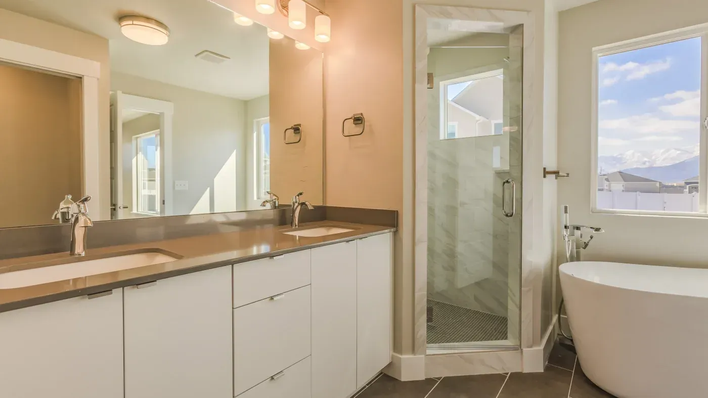 Modern master bathroom with dual vanity, walk-in shower with glass enclosure, soaking tub, and mountain views through window