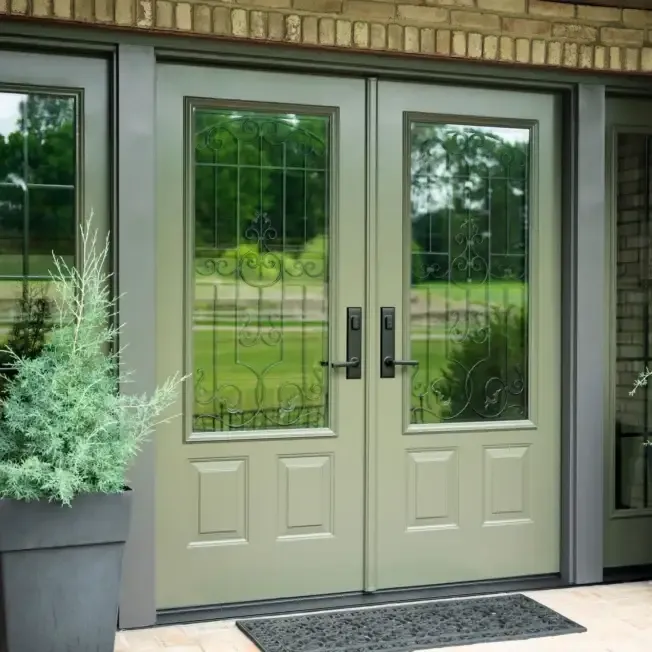 Cream-colored double French doors with decorative metal grilles and lower panels, opening to a sunny garden with green lawn and trees, flanked by potted silvery foliage plant