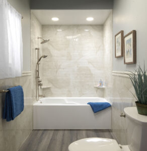 White bathtub and tile surround with overhead lighting and nickel hardware