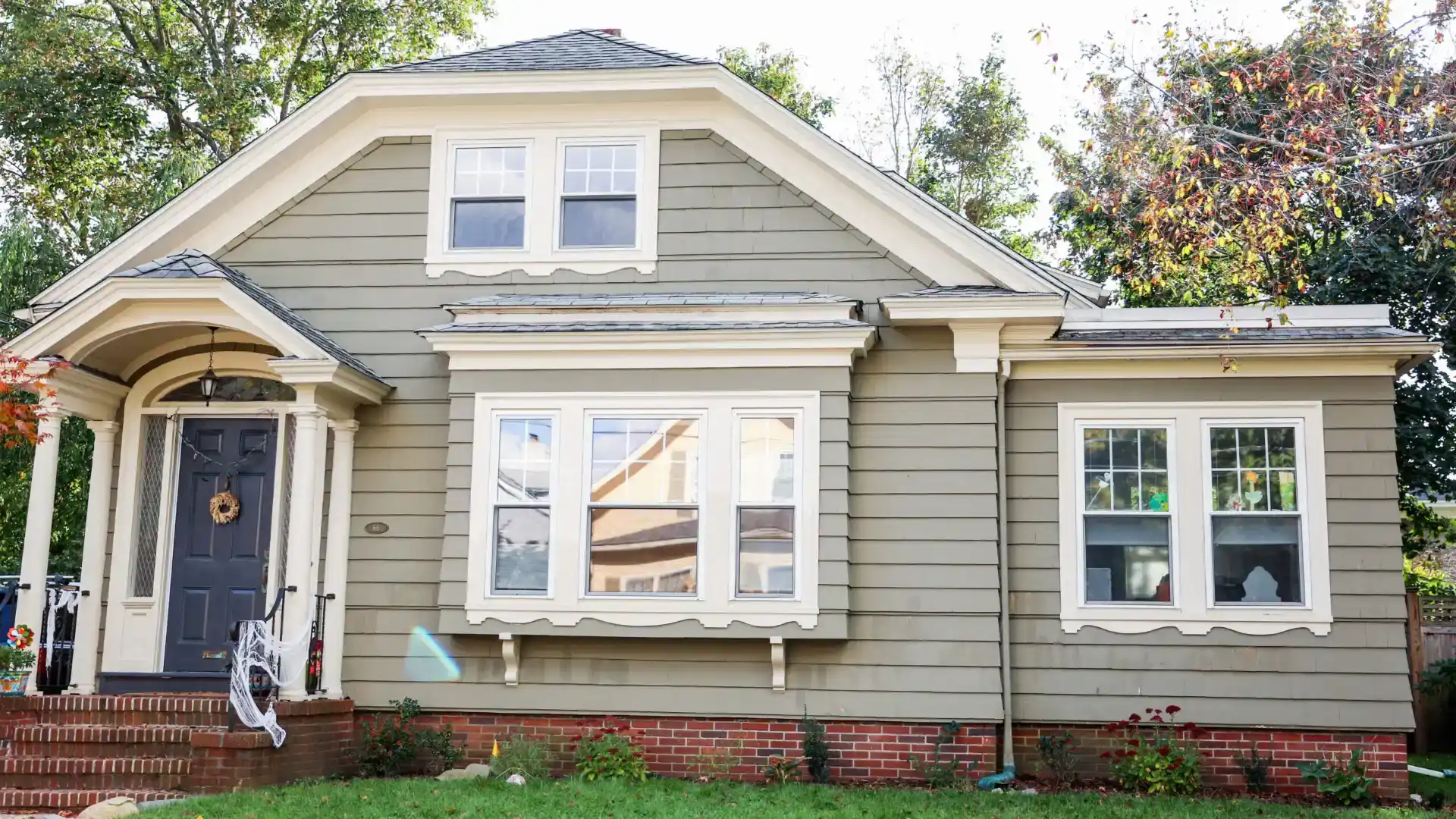 Small home with beautiful windows with white frames, blue entry door, and gray siding by siding contractors milwaukee and Belgium, WI | Exterior Pros