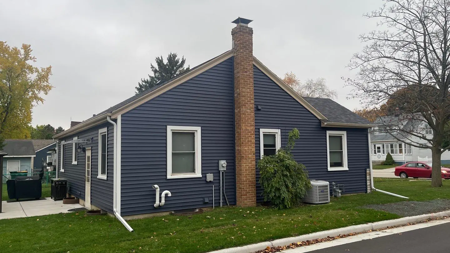 Exterior home repair with blue siding and nice landscaping in Brownsville, WI | Exterior Pros