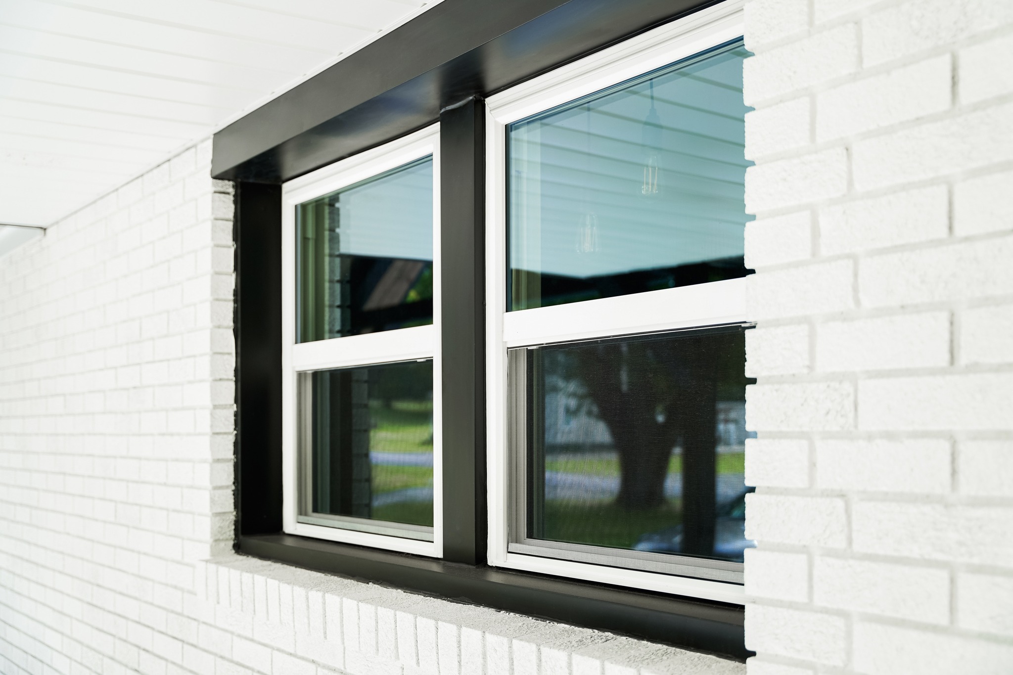 The image features a black and white framed window on a stylish home.